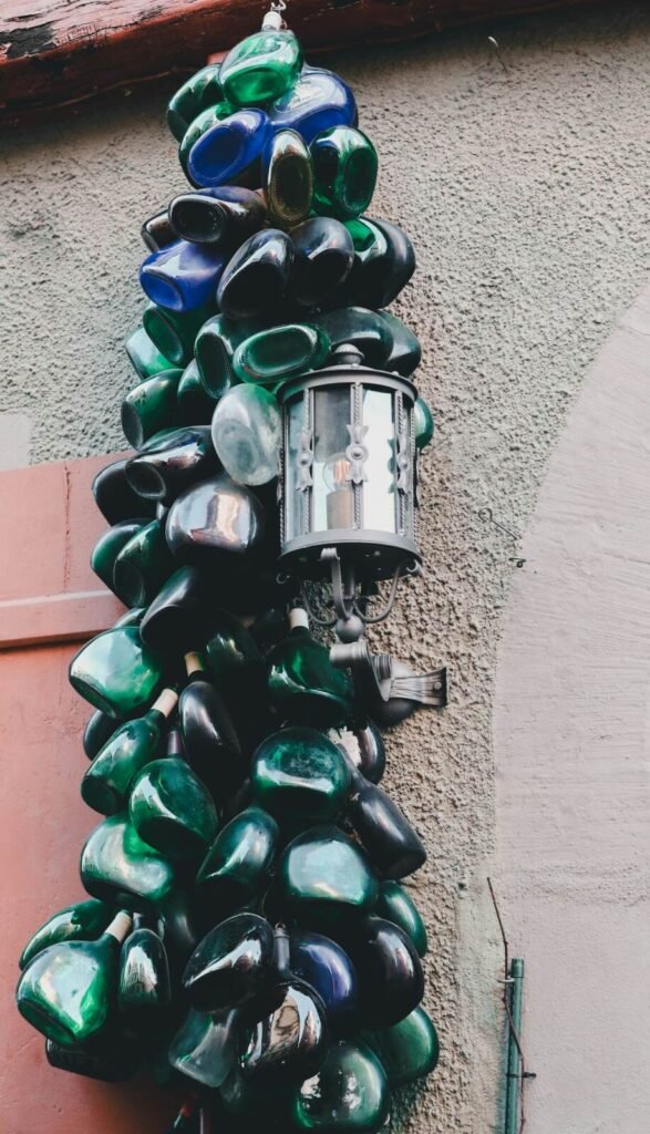 Green and blue glass bottles reused as a wall installation