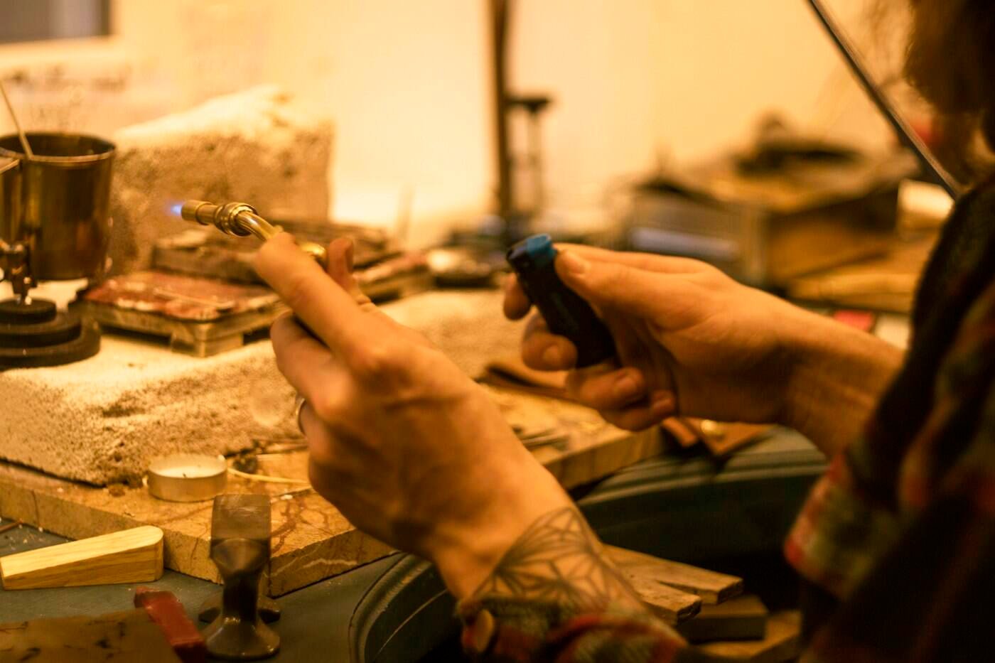 Hands crafting reclaimed copper into a new piece of art